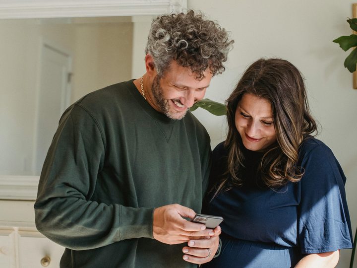 Couple checking their home's value together on a phone